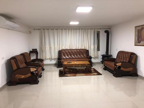 a living room with leather couches and a coffee table at Wonderful near Ram lake and Hermon mountain in Mas'ade