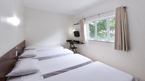 מיטה או מיטות בחדר ב-Araucaria Hotel Business - Maringá