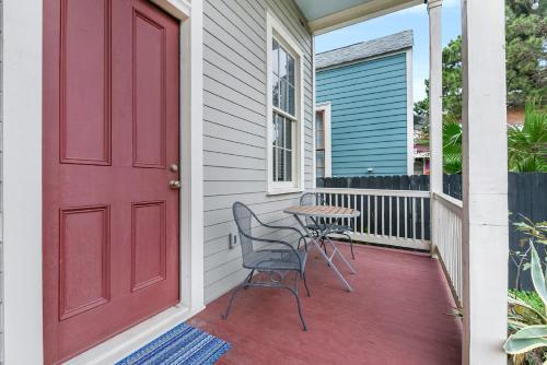 a red door on a porch with a table and chairs at Cozy and Charming House Close to St Charles Ave in New Orleans