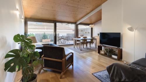 a living room with a couch and a tv and a table at APG Carrer Nou Atic in Girona