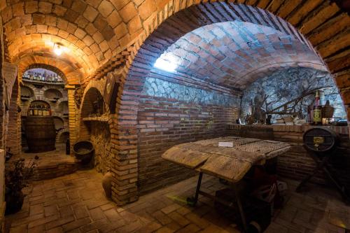 a stone room with a table in a brick wall at Hotel Rio Piedra in Nuévalos