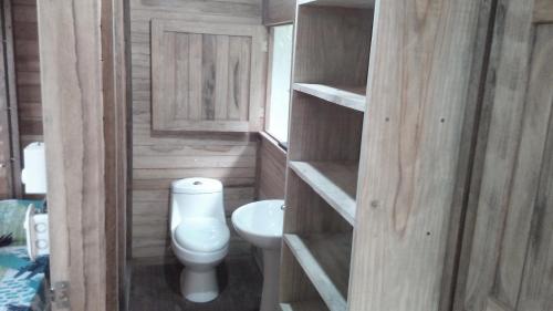 a small bathroom with a toilet and a sink at Finca Sueno de Osa in Puerto Jiménez