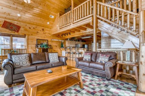 a living room with two couches and a staircase at Big Sky in Pigeon Forge