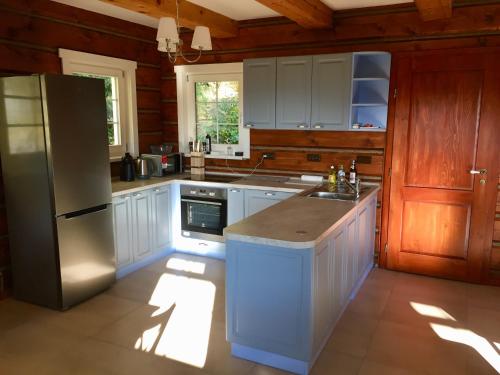 a kitchen with white cabinets and a refrigerator at Roubenka Ella in Desná