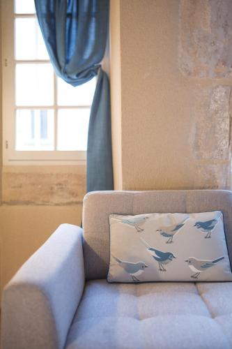 a pillow with dolphins on it sitting on a couch at La Tonnellerie in Beaune
