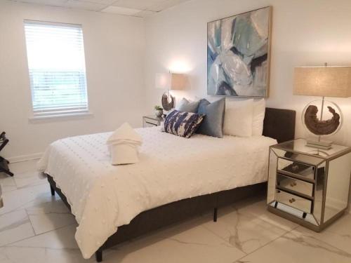 a bedroom with a large white bed with a night stand at 7BR- SLEEPS 15! Celebrity Villa! Great Rates!! in New Orleans