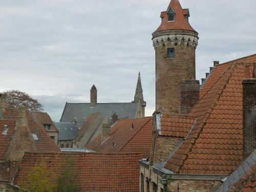 a view of roofs of buildings with a tower at Hotel Alegria in Bruges