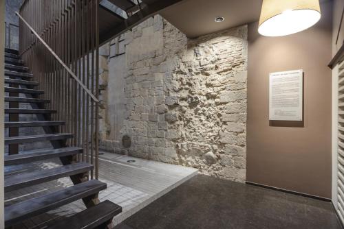a staircase in a building with a stone wall at APG Carrer Nou Atic in Girona