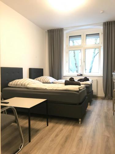 1 Schlafzimmer mit 2 Betten, einem Tisch und einem Fenster in der Unterkunft Holiday Apartments House in Essen