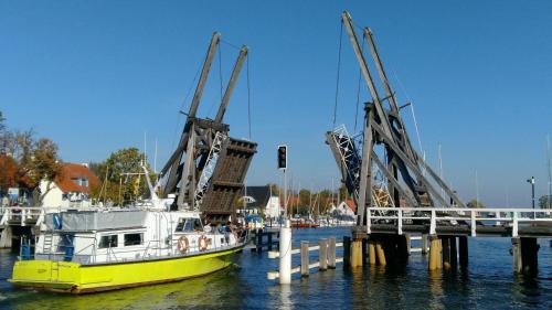 a yellow and white boat is docked at a dock at Zimmervermietung Koltermann in Greifswald