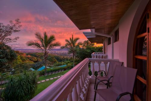 einen Balkon mit Blick auf den Sonnenuntergang in der Unterkunft Buena Vista Chic Hotel in Alajuela