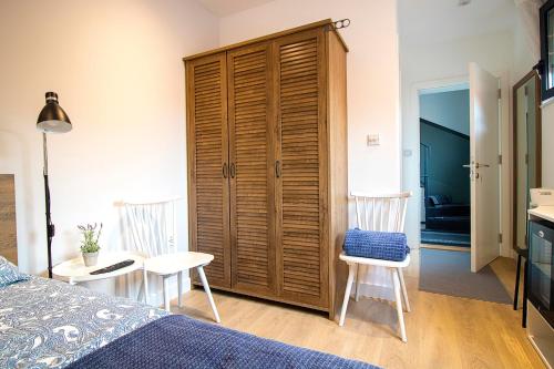 a bedroom with a bed and two chairs and a table at Nana / Sobe & Apartmani in Valjevo