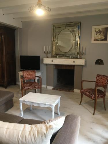 a living room with a fireplace and a mirror at maison de charme dans village médieval in Les Marches