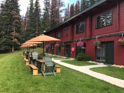 a group of chairs and tables outside of a red building at Miette Hot Springs Bungalows in Jasper