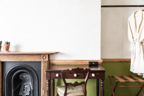 a chair next to a table and a fireplace at The Bull Inn in Totnes