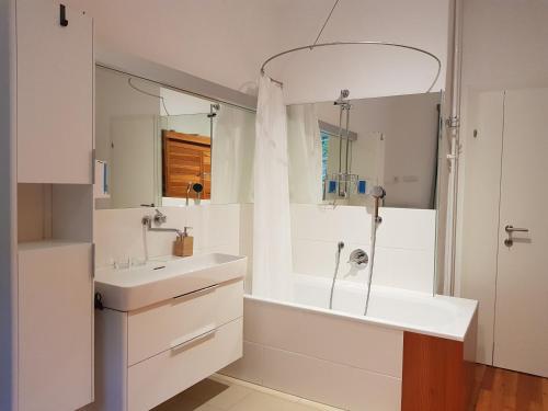 a white bathroom with a tub and a sink at Gästehaus Grogger in Weyer Markt