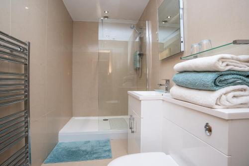 a bathroom with a shower and a toilet and a sink at Finest Retreats - Sea Views Cottage in Prestatyn