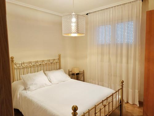 sypialnia z białym łóżkiem i oknem w obiekcie Pilatos w mieście Zamora