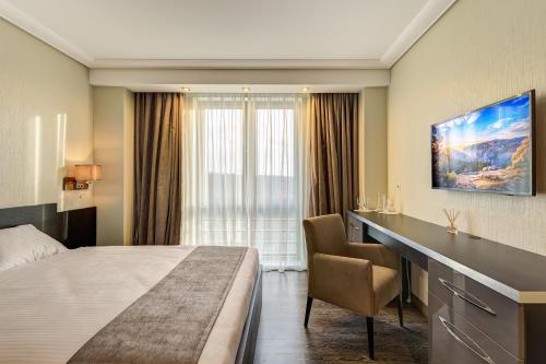 ヴィドノエにあるAstro Plazaのベッドとデスクが備わるホテルルームです。