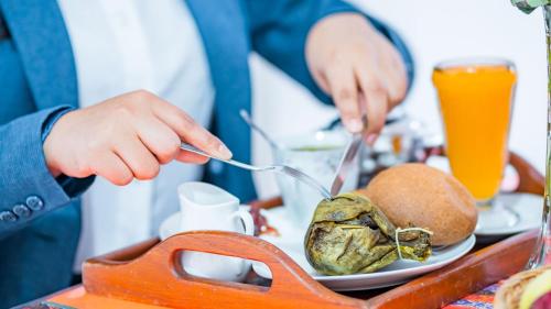 a person eating food on a table with a plate of food at Hotel Chachapoyas in Chachapoyas