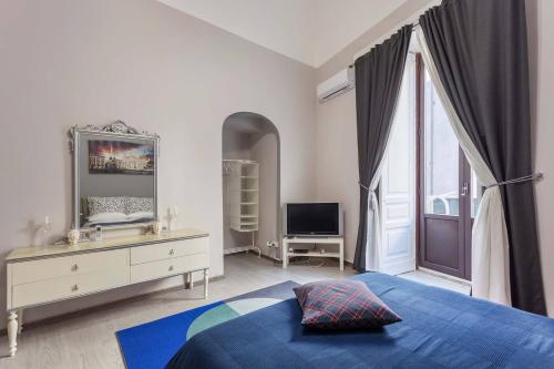 um quarto com uma cama, uma cómoda e um espelho em Two Rooms Bellini em Catânia