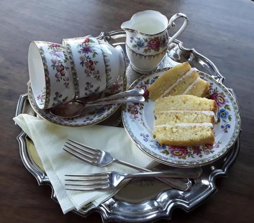 a tray with two plates of cake and a cup at Ellerton Lodge Bed and Breakfast Swaledale in Richmond