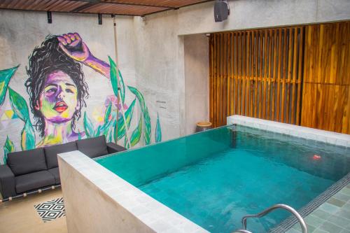 a swimming pool with a mural of a woman at Diez Diez Collection in Mérida