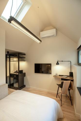 a bedroom with a bed and a desk and a tv at THE ADAMS - Self Check In Hotel in Baden-Baden