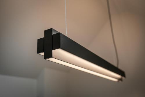 a black and white light hanging on a wall at THE ADAMS - Self Check In Hotel in Baden-Baden