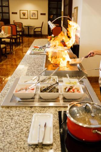 a buffet line with food on fire in a restaurant at Barceló Guatemala City in Guatemala