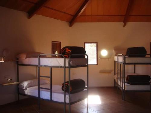 Trujillanos的住宿－ALBERGUE TURÍSTICO DE CORNALVO，一间房间,设有三张双层床