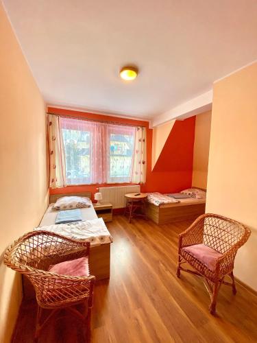 a room with two beds and a chair in it at Na Kośnych in Poronin
