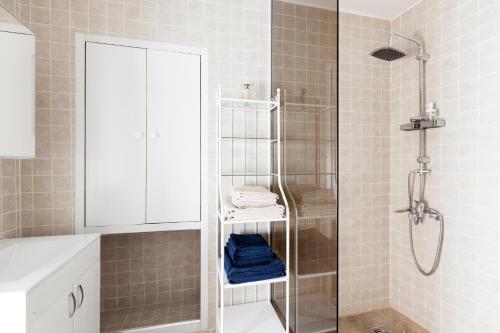 uma casa de banho com um chuveiro e uma cabina de duche em vidro. em Balkan-Inn Apartments em Belgrado