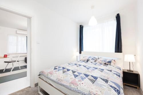 a white bedroom with a bed and a mirror at Balkan-Inn Apartments in Belgrade