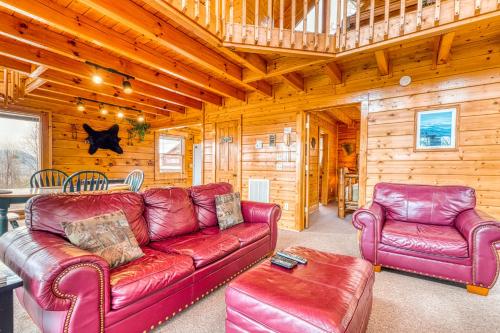 a living room with red leather furniture in a cabin at Just the Two of Us in Pigeon Forge
