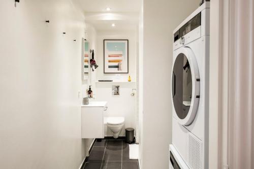 y baño con aseo y lavadora. en Town Hall Apartments by Daniel&Jacob's, en Copenhague