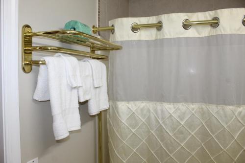 y baño con cortina de ducha y toallas blancas. en Liberty Inn, en Galloway