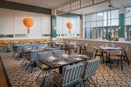 a dining room with tables and chairs and windows at Ocean Coral Spring Resort - All Inclusive in Falmouth