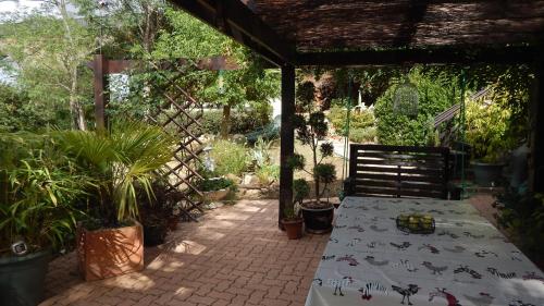 a patio with a table and a chair with plants at The Petite Chalet Chambre d'hôtes in LʼIsle-Jourdain