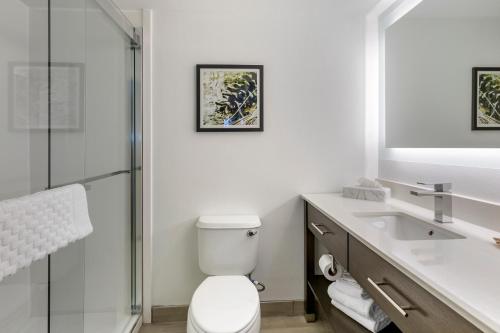 a white bathroom with a toilet and a sink at Franklin Extended Stay Hotel in Franklin