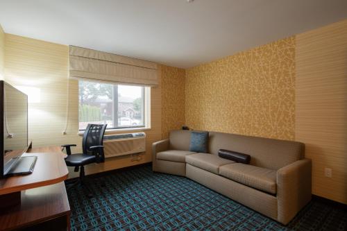 a living room with a couch and a desk at Fairfield Inn & Suites by Marriott New York Queens/Fresh Meadows in Queens