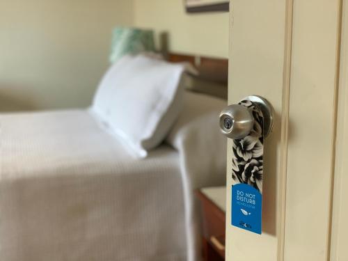 a room with a bed and a door with a tag at Hotel Acosta in Iquitos