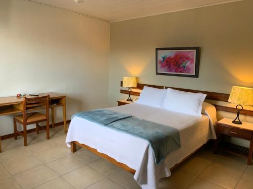 a bedroom with a bed and a desk and a desk at Hotel Acosta in Iquitos