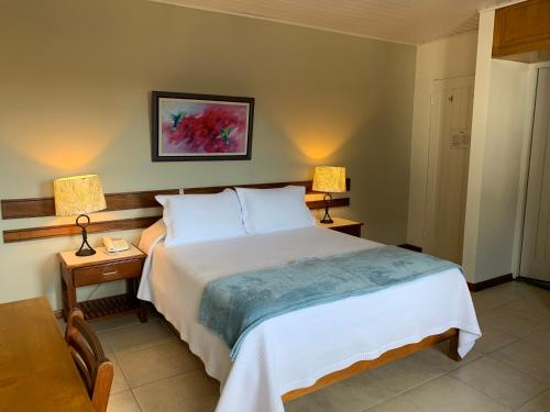 a bedroom with a bed and two lamps and a couch at Hotel Acosta in Iquitos
