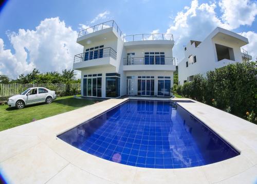 una casa con una piscina di fronte di VILLA MANDALAY a Santa Verónica