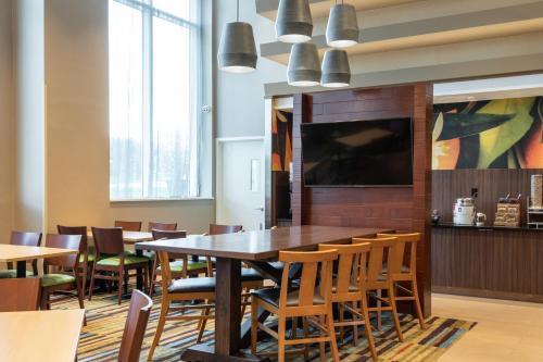 une salle à manger avec une grande table et des chaises dans l'établissement Fairfield Inn & Suites by Marriott New York Queens/Fresh Meadows, à Queens