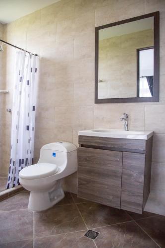 a bathroom with a toilet and a sink and a mirror at VILLA MANDALAY in Santa Verónica