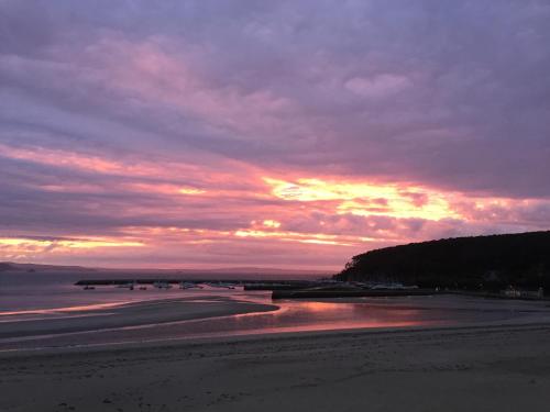 a sunset on a beach with a cloudy sky at L'Imprenable vue mer in Crozon