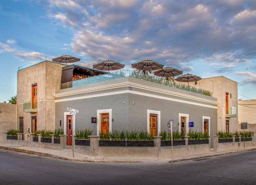 a building with umbrellas on top of it on a street at Diez Diez Collection in Mérida