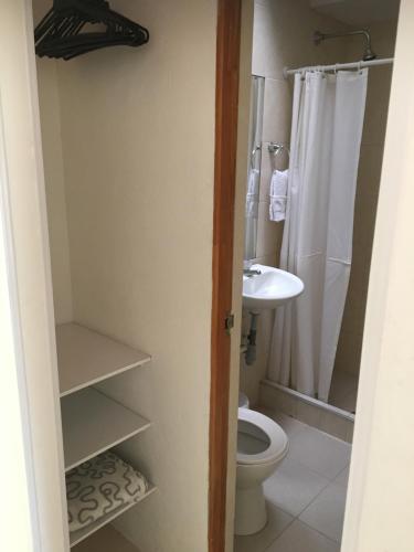 a bathroom with a toilet and a sink at Hotel Hacienda El Diamante in Villeta